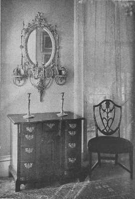 A valuable collection of an Adam mirror, a block-front,
 knee-hole chest of drawers, and a Hepplewhite chair.