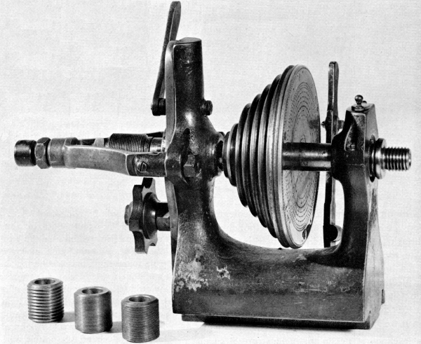 Figure 16.&mdash;Headstock of a German instrument-maker&rsquo;s
lathe, typical of the mid-19th century, showing the traverse spindle,
interchangeable lead screws, and semicircumferential nut containing
several leads. The nut may be brought into engagement by the lever at
top rear of the headstock. This releases the end thrust control on the
spindle simultaneously with engagement of the nut. (Smithsonian photo
49839.)