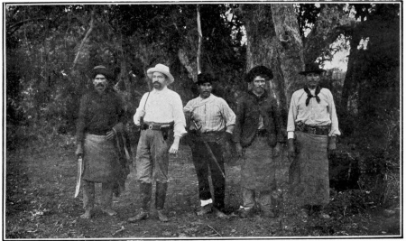 BLASCO IBÁÑEZ EN COMPAGNIE DE QUATRE MÉTIS&mdash;DONT
QUELQUES-UNS PORTENT L’ÉPÉE CROISÉE À LA CEINTURE, EN SOUVENIR DE
L’ÉPOQUE DES CONQUISTADORS&mdash;DANS SA COLONIE «NUEVA VALENCIA»